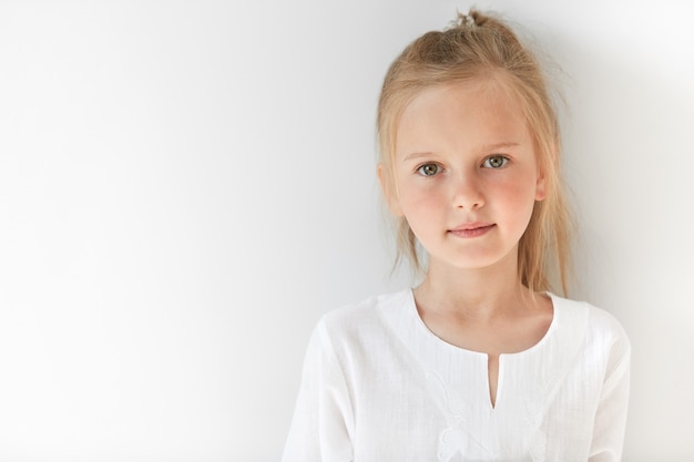 Little blonde girl wearing white blouse