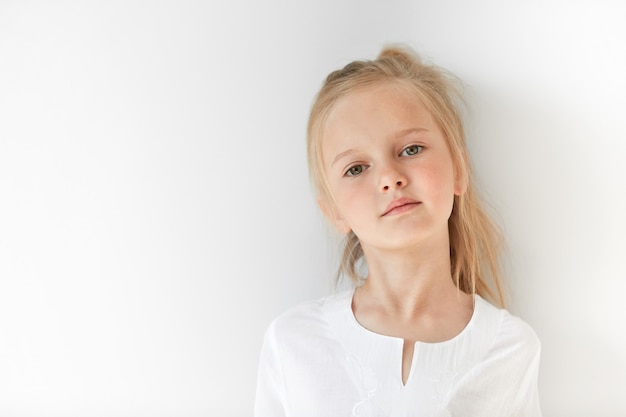 Little blonde girl wearing white blouse