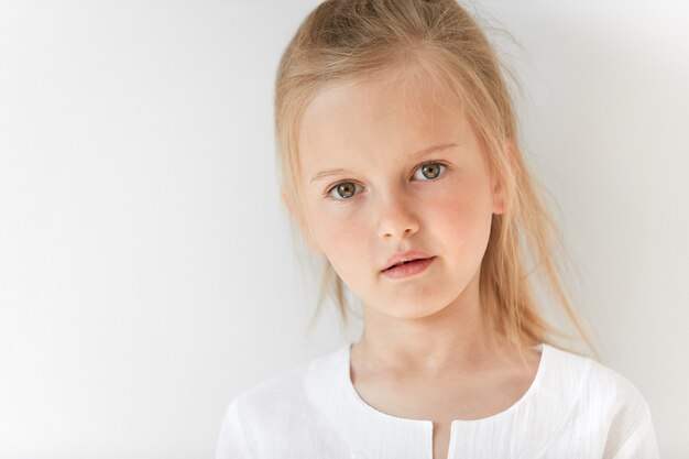 Little blonde girl wearing white blouse