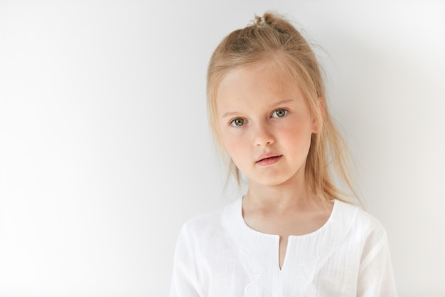 Little blonde girl wearing white blouse