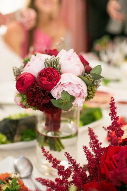 Little bouquet of peonies stands in tall vase with water 