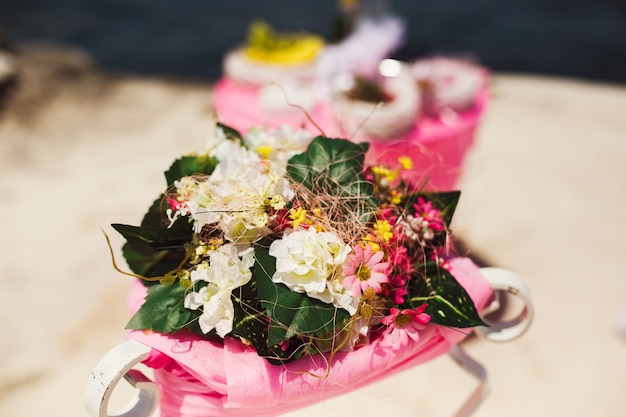 Little bouquets of pink and white field flowers lie on a table