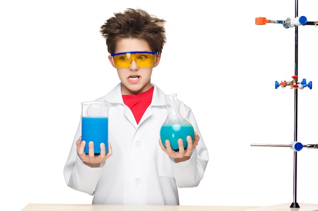 Free photo little boy as chemist doing experiment with chemical fluid in the laboratory