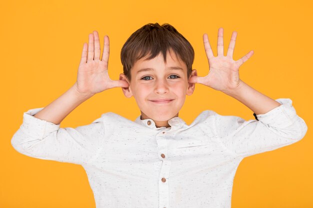 Little boy being silly with orange background
