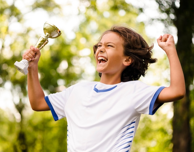 Little boy being victorious after a match of football