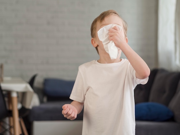 Free photo little boy blowing nose