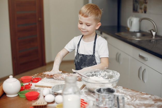 Little boy cook the dough for cookies