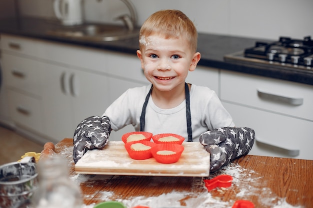 Little boy cook the dough for cookies