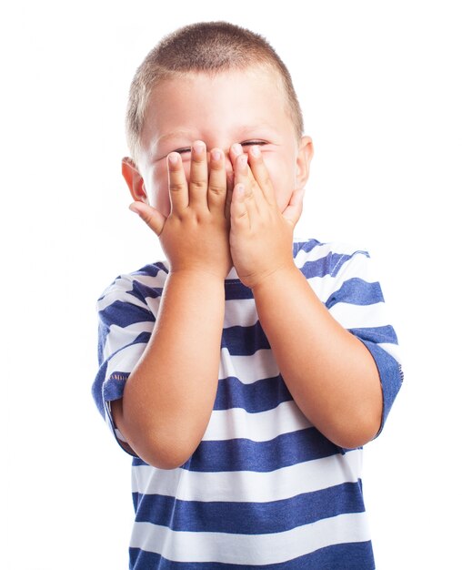 Little boy covering his face with both hands