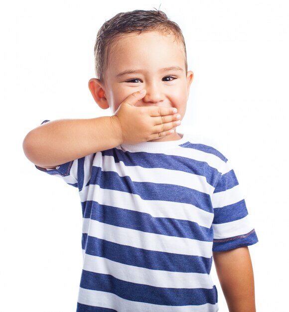 Little boy covering his mouth while laughing