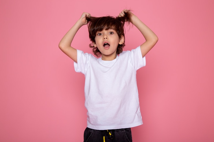 Free Photo little boy cute adorable sweet in white t-shirt and grey trousers on pink wall