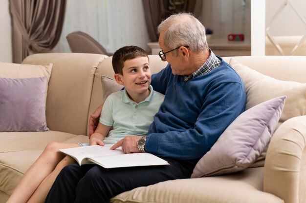 Little boy doing homework with his grandfather at home