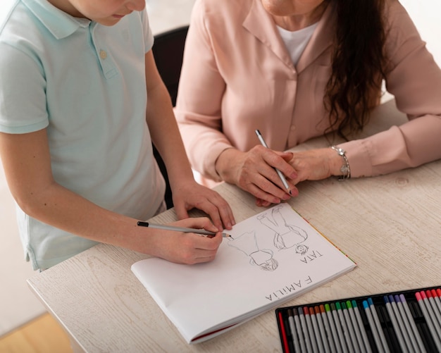 Little boy doing homework with his grandmother