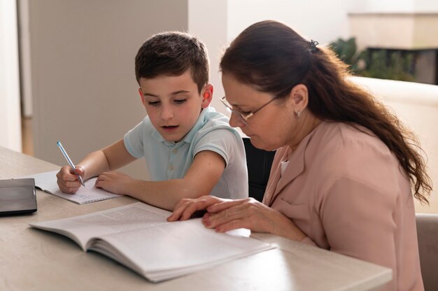 Маленький мальчик делает домашнее задание со своей бабушкой