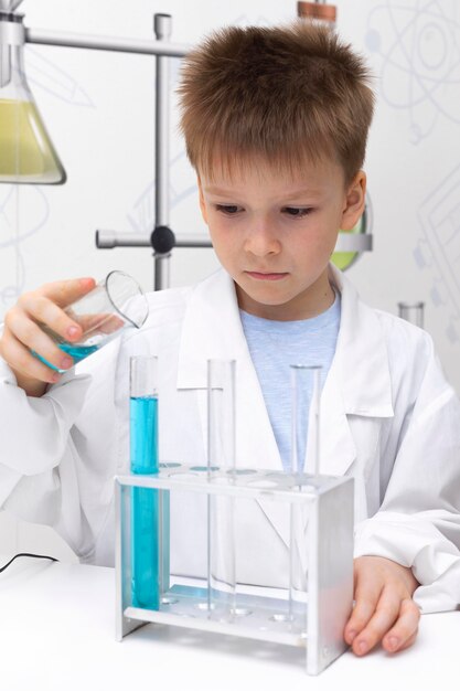 Little boy doing a science experiment at school