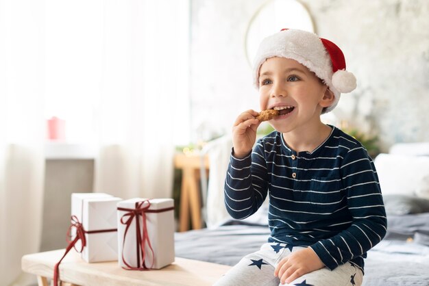 Маленький мальчик ест рождественское печенье