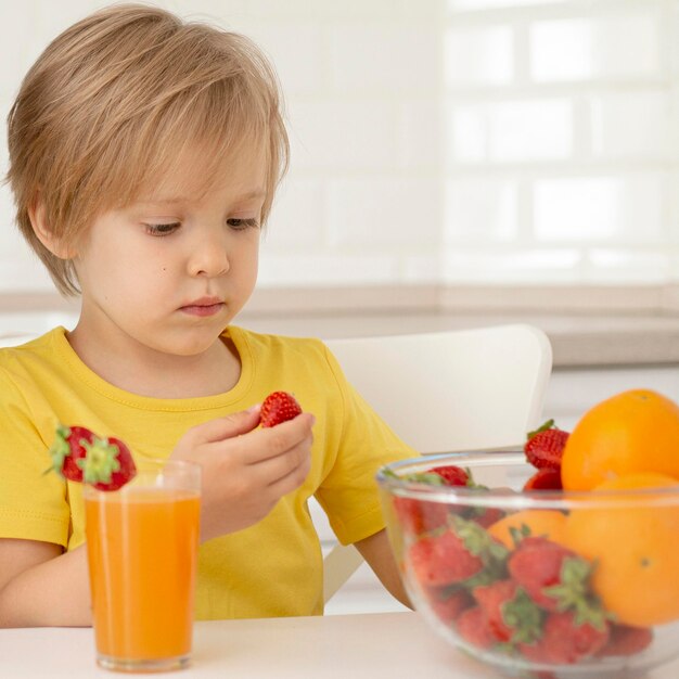 Little boy eating fruits