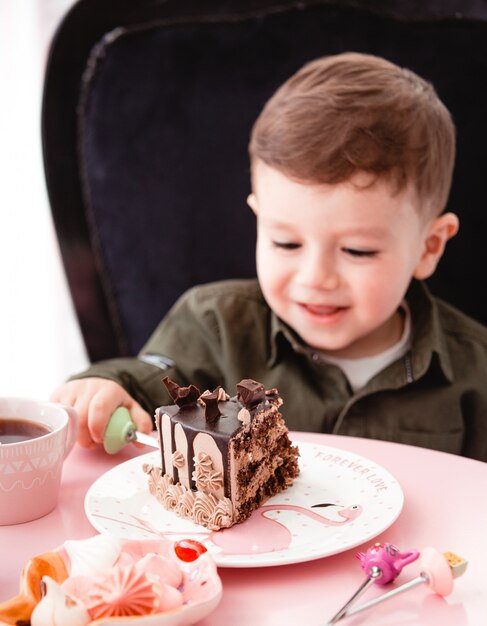 Little boy eats chocolate cake