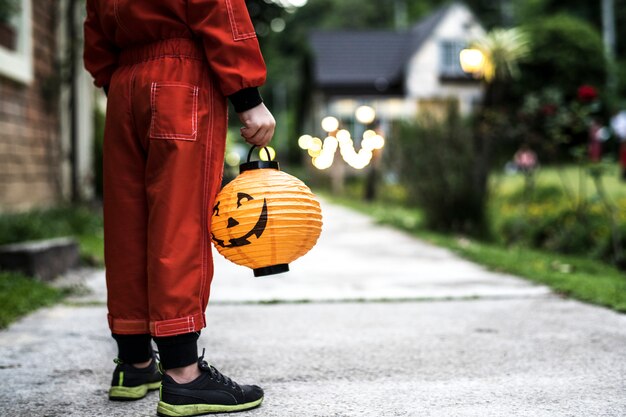 Маленький мальчик, держащий фонарь Хэллоуина