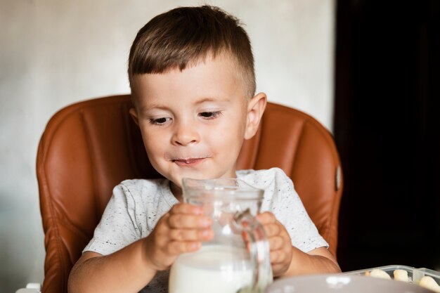 Little boy holding a jar of milk