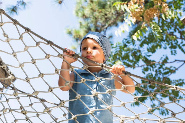 Free photo little boy holding net and looking away