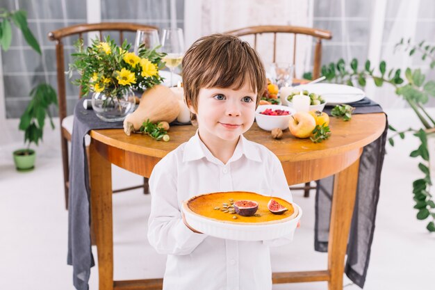 Little boy holding pie in hands 