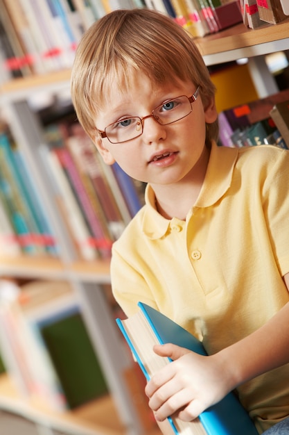 Little boy holding a thick book