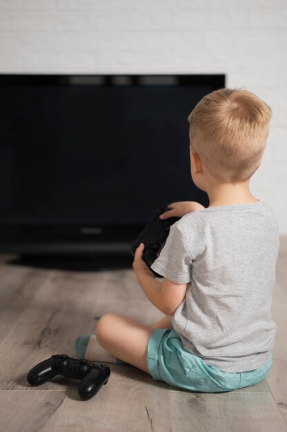 Little boy at home playing digital games 