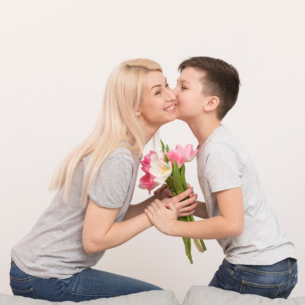 Little boy kissing his mom