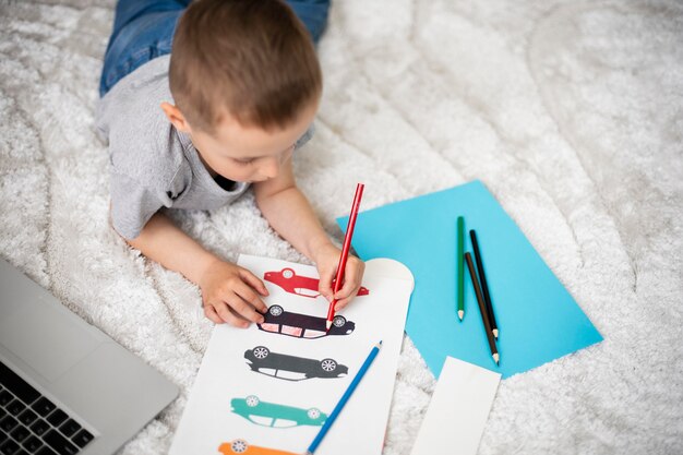 Маленький мальчик учится рисовать