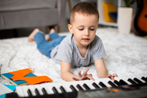 Маленький мальчик учится играть на пианино