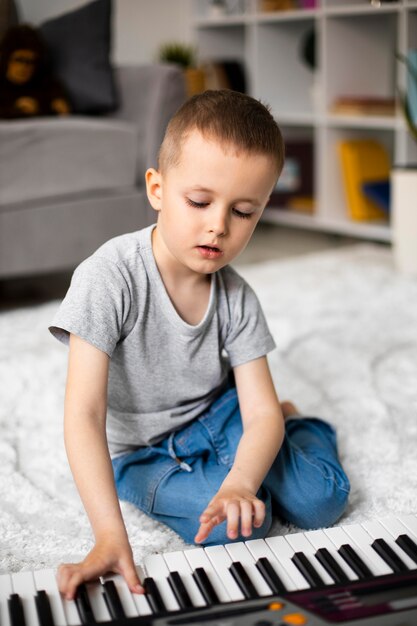 Little boy learning how to play the piano