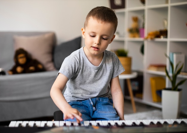Little boy learning how to play the piano