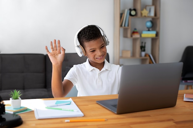 Little boy listening to his teacher through headphones