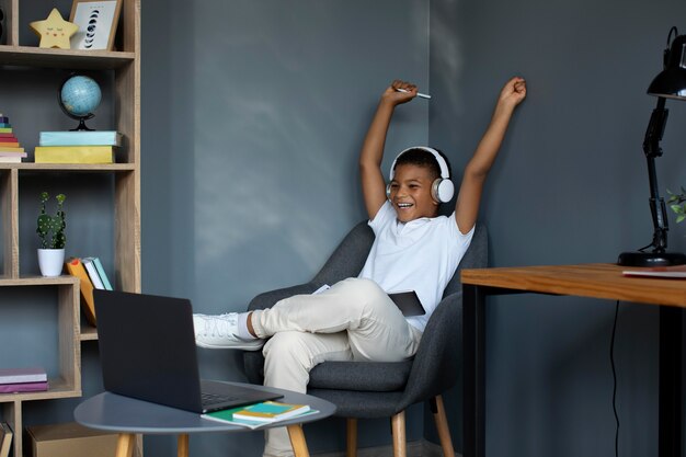 Little boy listening to his teacher through headphones