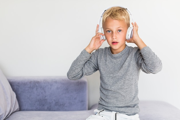 Free photo little boy listening music at home