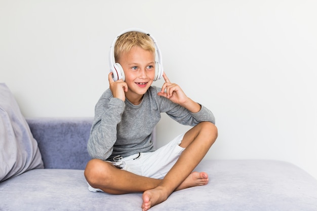 Маленький мальчик слушает музыку дома