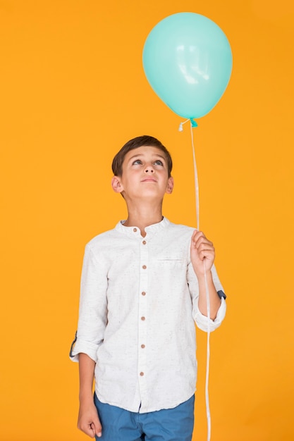 Foto gratuita ragazzino che esamina un pallone blu