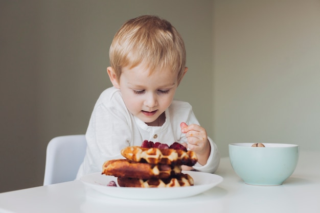 Free photo little boy looking at waffle