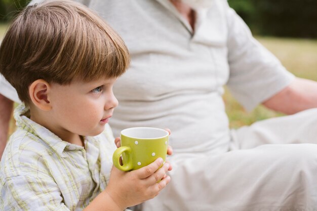 Little boy outdoor drinking tea