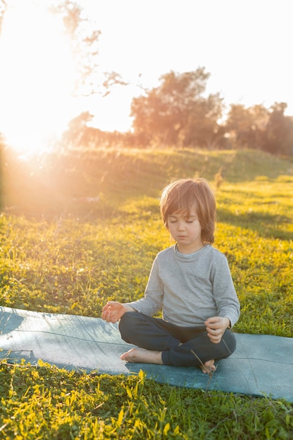 Little boy meditando all'aperto