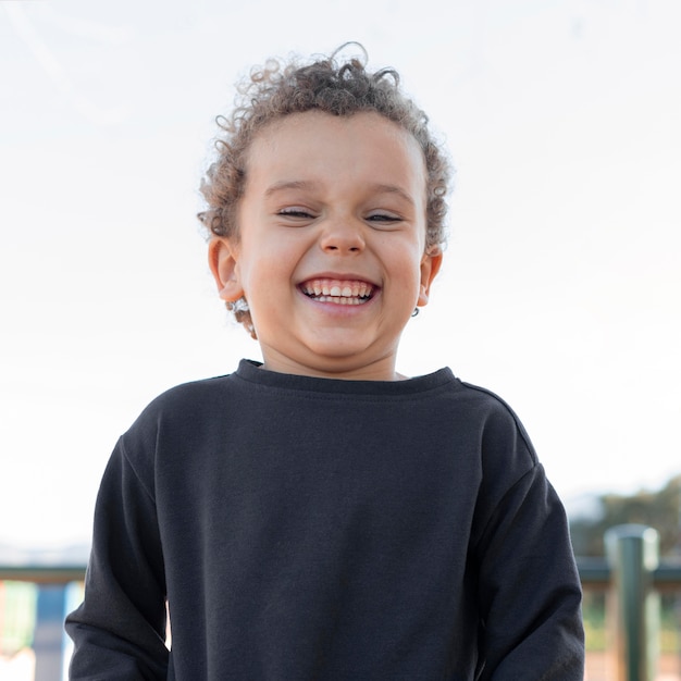 Бесплатное фото Маленький мальчик на открытом воздухе улыбается