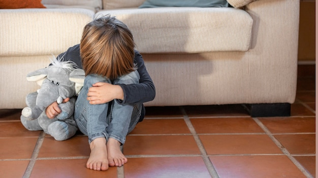 Little boy outdoors upset holding his toy