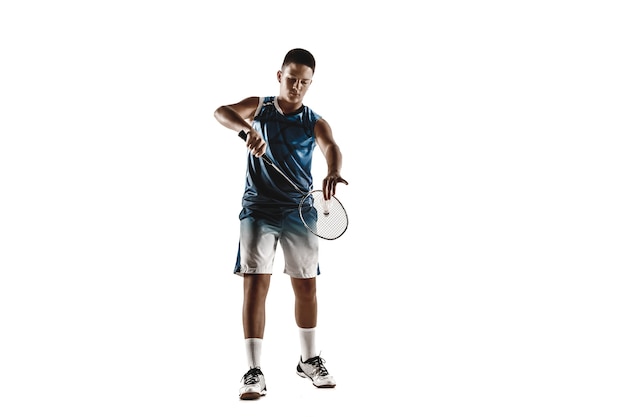 Little boy playing badminton isolated on white studio background. Young male model in sportwear and sneakers with the racket in action, motion in game. Concept of sport, movement, healthy lifestyle.