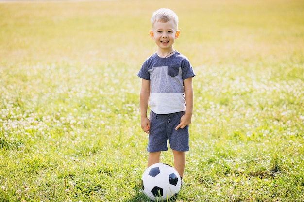 Little boy playing football at the field