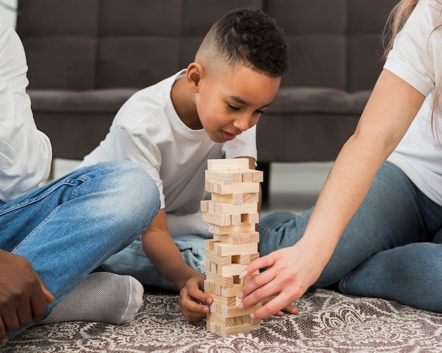 Free photo little boy playing a game with his parents