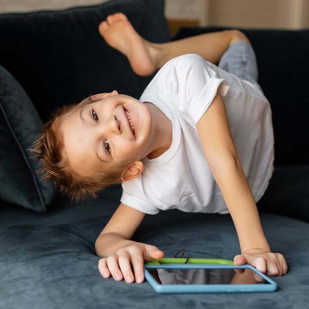 little boy playing on the phone at home