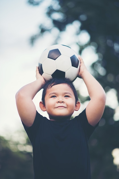 Little boy che gioca a calcio di calcio