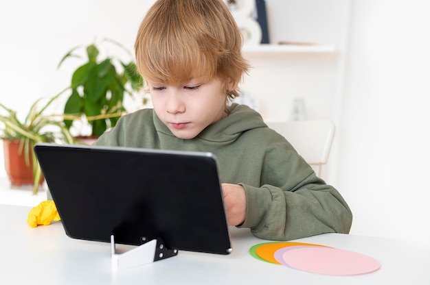 Free photo little boy playing on the tablet