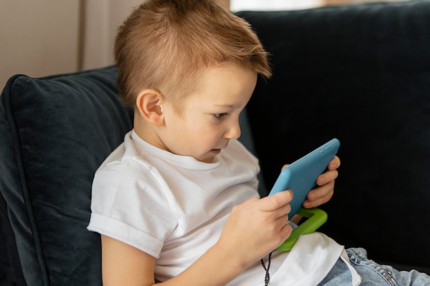 Little boy playing video games on the phone